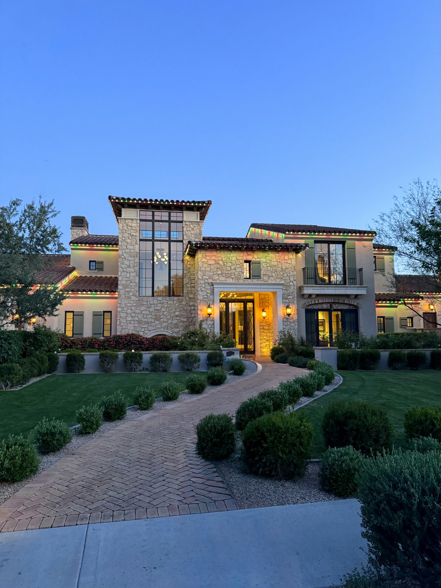 Mediterranean estate at dusk with landscape lighting